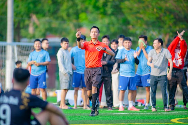 A photo of a referee during a football match about to make a decision.