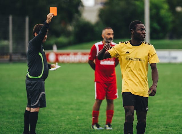 A referee sending a player off during a football match.