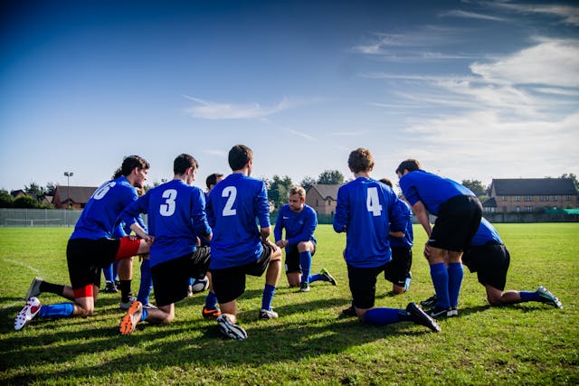 A photo showing a football team warming up with nine visible players.